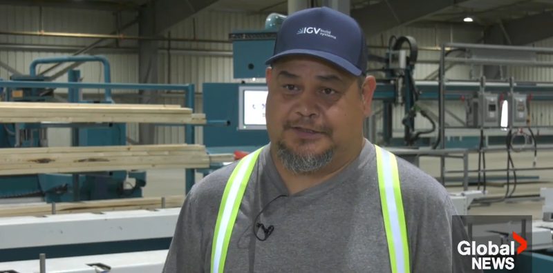 An IGV Build Systems worker wearing a company cap being interviewed on the manufacturing floor